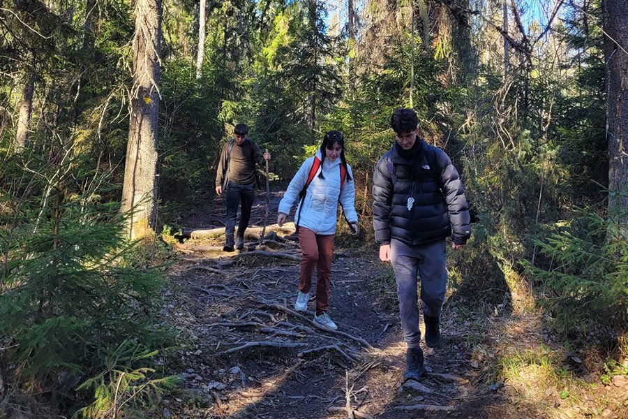 Antonio (right) hiking through a Finnish forest with friends